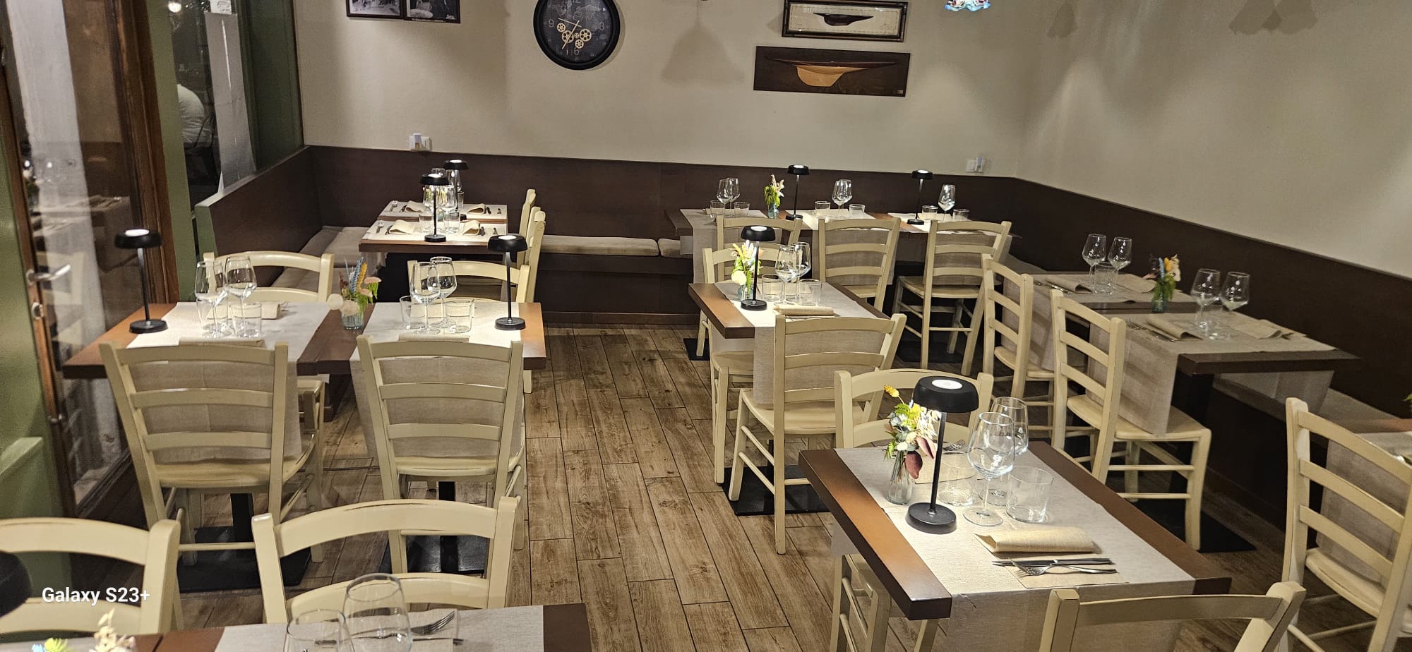 Interno dell'Osteria Il Bacio con tavoli in legno apparecchiati e lampade moderne